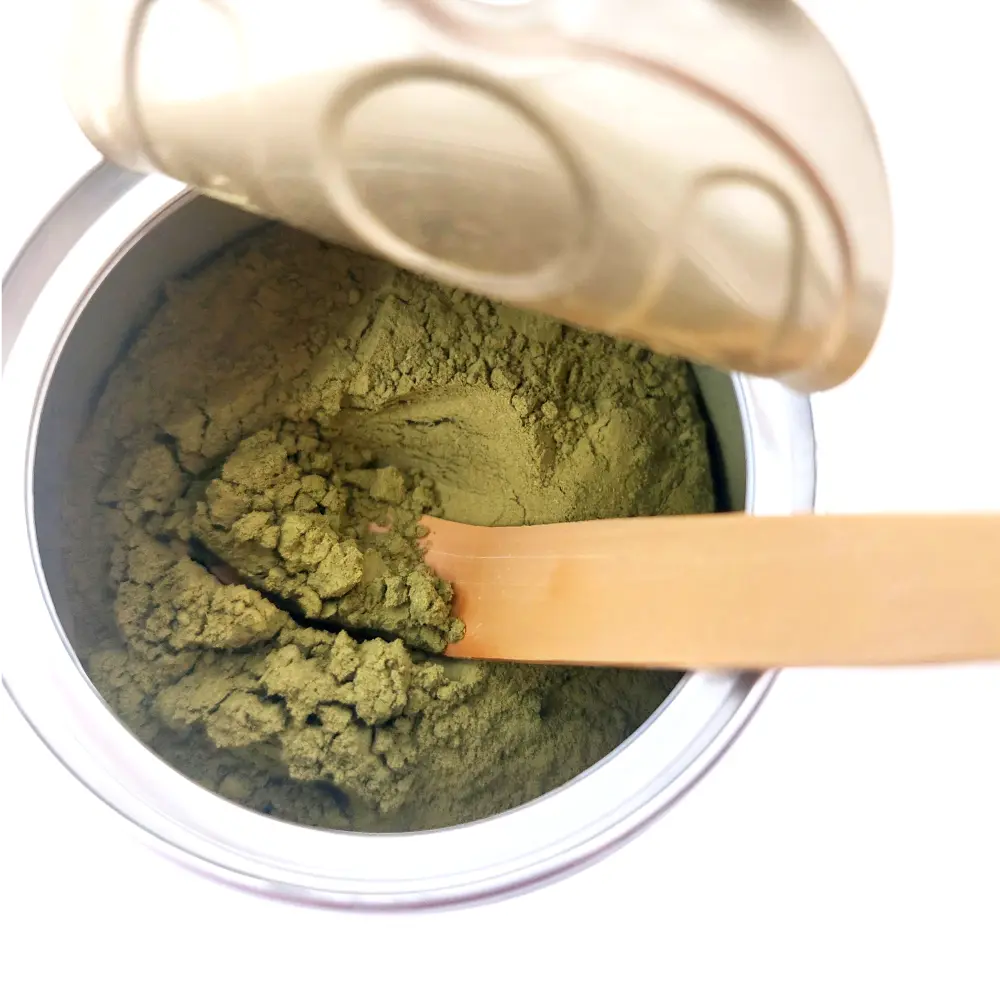 Alveus matcha teapor a fémtégelyében, a tégelyben tradicionális bambusz matcha mérőkanállal éppen a matchát veszik ki.