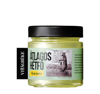 Virágbéke "Átlagos hétfő" akácméze látható, a méz színe szép, aranyszínű sárga. A kupak fekete. 