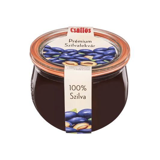 Csattos üvegben sötétlila színű szilvalekvár átlátszó üvegben, a címeke ízlésesen fut függölegesen körbe az üvegen. 