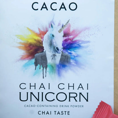 A képen a Chai Chai Unicorn felirat látható, meg egy fehér unikornis, aki öltönyben van és körülette szívárvány színű füst lebeg. 
