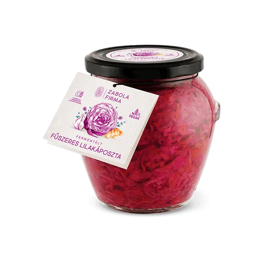 Fermentált fűszeres lilakáposzta látható a Lardershelf kínálatából. Az üvegben elkészített lilakáposzta látható, amelynek lila a színe. Az üveg kupakja fekete. A címkén egy felbevágott lilakáposzta látható, mellette fokhagyma és gyömbér van. 