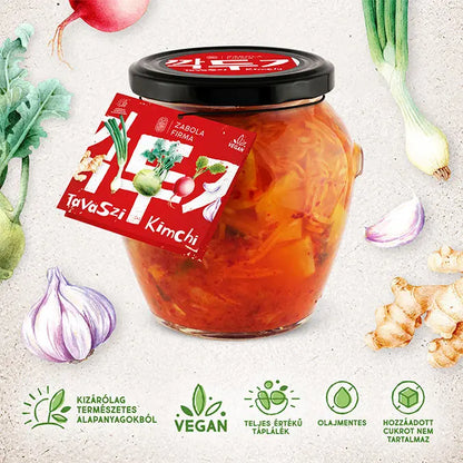 Tavaszi kimchi látható a képen a Lardershelf kínálatából. Az üveg körül mindenféle zöldség grafikája (úhagyma, gyömbér, retek, fokhagyma) helyezkedik el. Az üveg igényesen kialakított és fekete kupakkal van lezárva. 