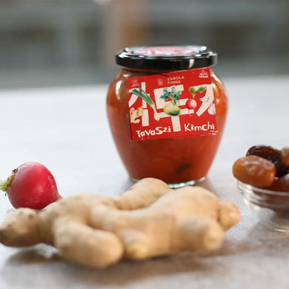 Zabola Firma által készített tavaszi kimchi látható. A kép előterében gyömbér, retek és egy pár aszalt gyümölcs látható. 