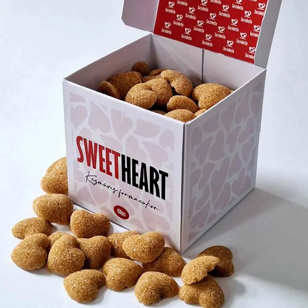 Sucrobello szívalakú formacukra látható, amely a karamellizáció miatt barna színű. A doboz színe fehér, szívek vannak rajta, a dobozban formacukrok vannak. A doboz előtt szintén formacukrok találhatóak. 