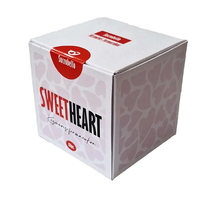 Sucrobello szívalakú formacukra látható. A doboz színe fehér, a "Sweet" szó piros, a dobozon fehér színű szívecskék vannak. 