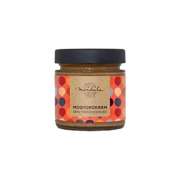 Mendula 100% törökmogyorókrém, az üvegben látszik a szépen elkészített mogyorókrém. A címkén piros, krém, kék és narancssárga pötyök láthatóak, a címke alapszíne a világos narancssárga. A kupak színe fekete. 
